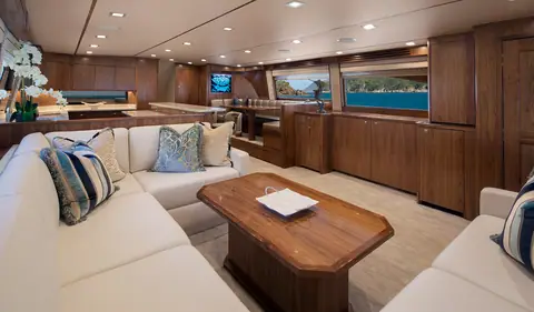 Viking 80 Convertible salon with a cream U shaped settee, walnut coffee table and galley aft