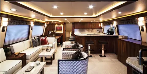 Viking 92 Convertible salon with an L shaped sofa, bar stools and a galley aft of the windows