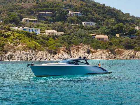 Blue gray Wajer 55 HT at anchor in a turquoise bay below hillside villas