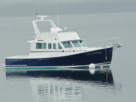 Wesmac 42 flybridge cabin cruiser Christine with a dark blue hull lying on a mooring
