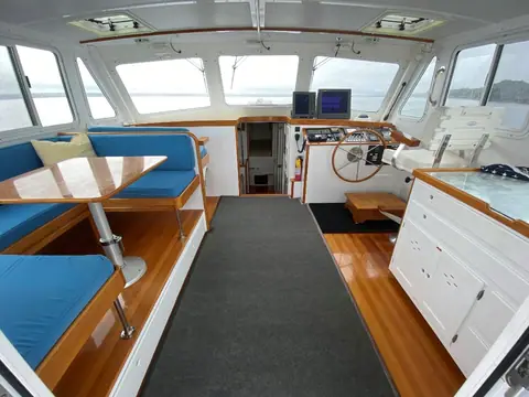 Wesmac 42 Fetch pilothouse with blue dinette, teak and holly sole and helm forward