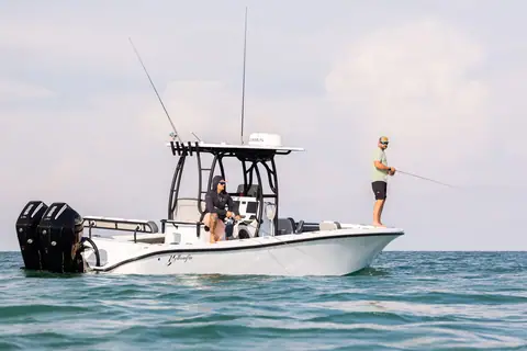 Yellowfin 26 Hybrid center console with twin outboards as an angler casts from the bow
