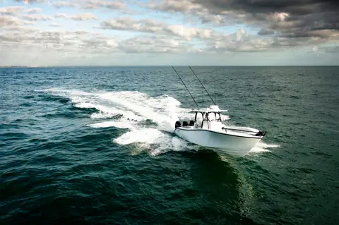 Yellowfin 34 Offshore carving a wide turn on open water under a cloudy sky