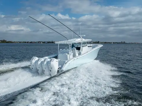 Yellowfin 42 Offshore seen from astern running with quad white outboards and a wide wake