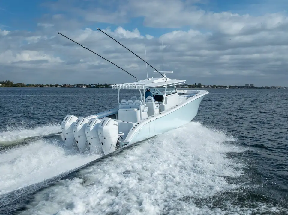 Yellowfin 42 Offshore seen from astern running with quad white outboards and a wide wake