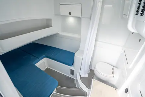 Yellowfin 42 Offshore console cabin with a blue cushioned berth and enclosed head