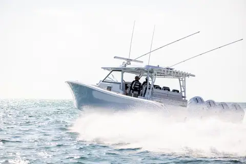 Yellowfin 54 Offshore running at speed with quad outboards and spread outriggers