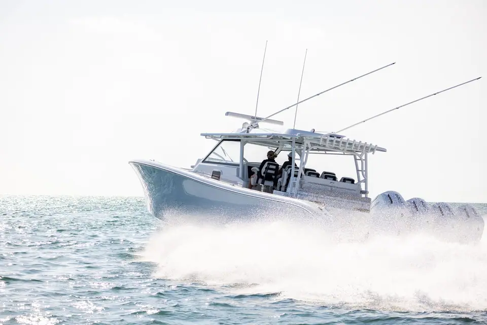 Yellowfin 54 Offshore running at speed with quad outboards and spread outriggers