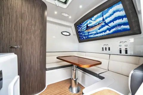 Yellowfin 54 Offshore console cabin with a dinette, teak table and marlin artwork